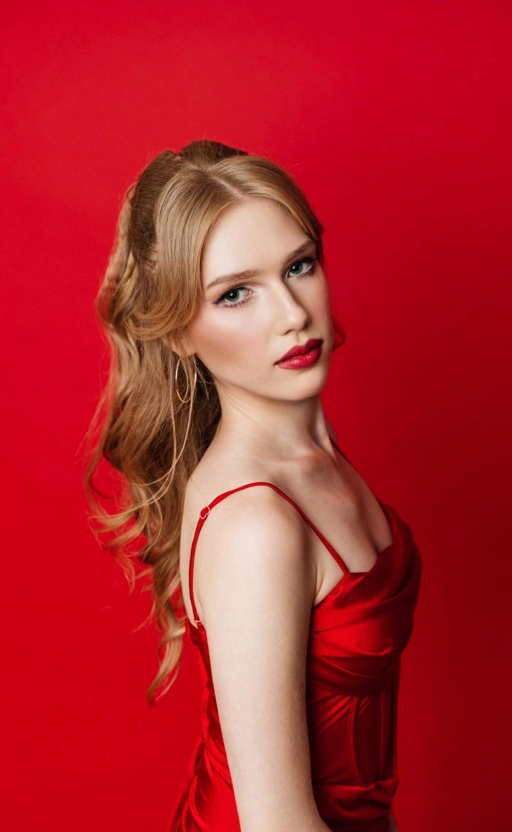 Polished occasion makeup with red lipstick for a woman in a red dress