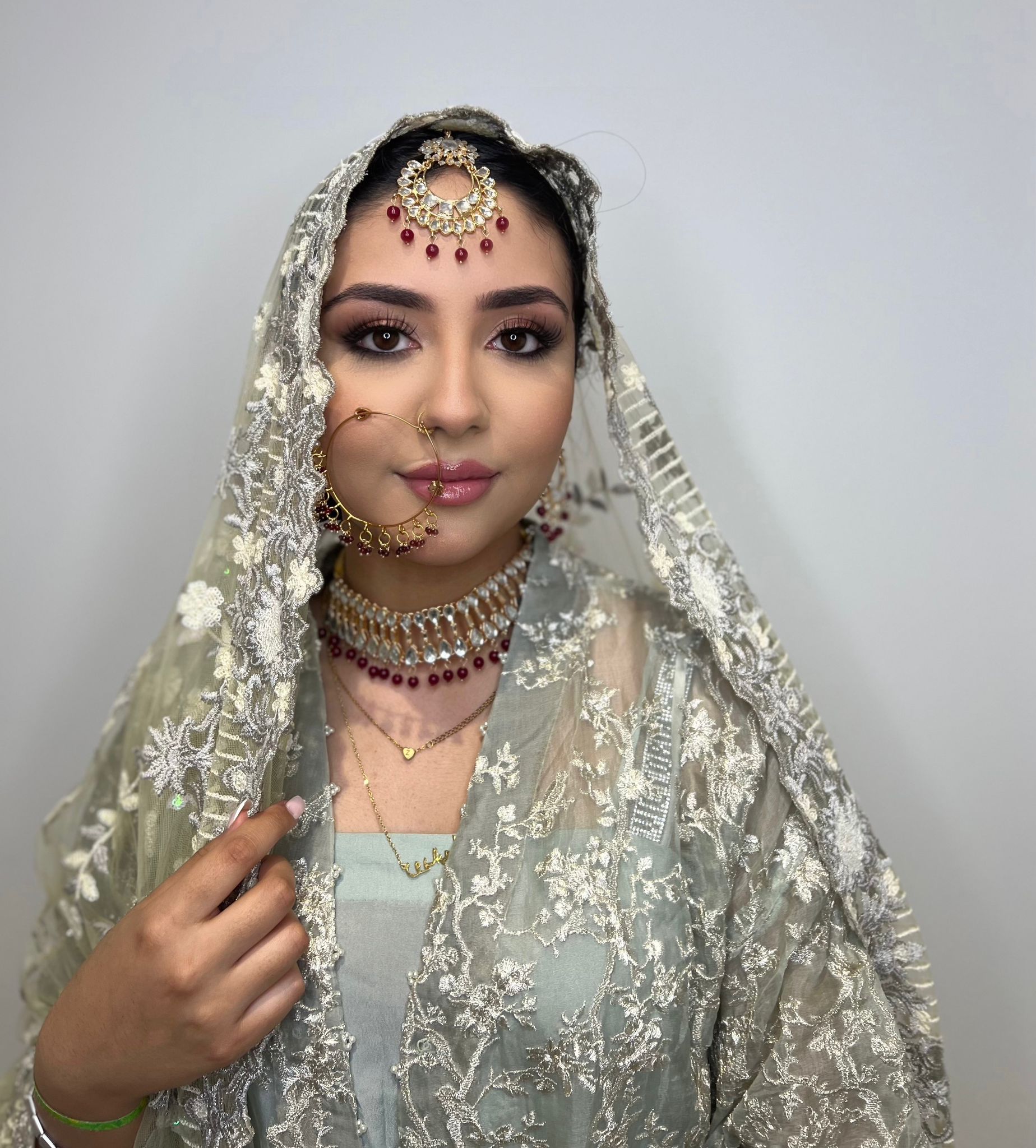 South Asian bridal makeup with a silver embroidered dupatta